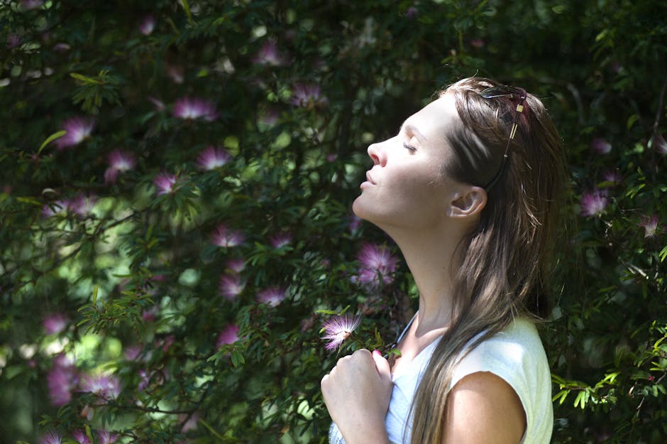 breathing exercises for stress and anxiety relief - A woman enjoying a serene moment in a sunlit garden, surrounded by vibrant flowers.