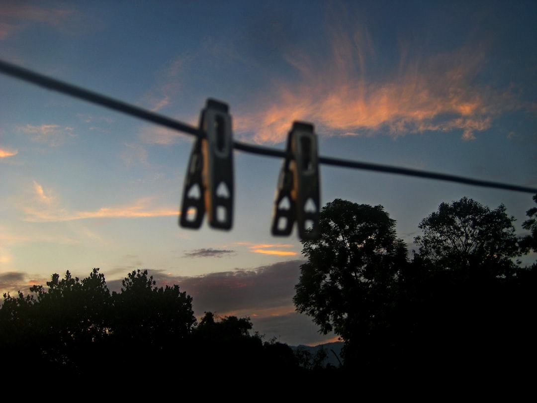 screen time management and digital detox strategies - Two clothespins hang on a wire at sunset.
