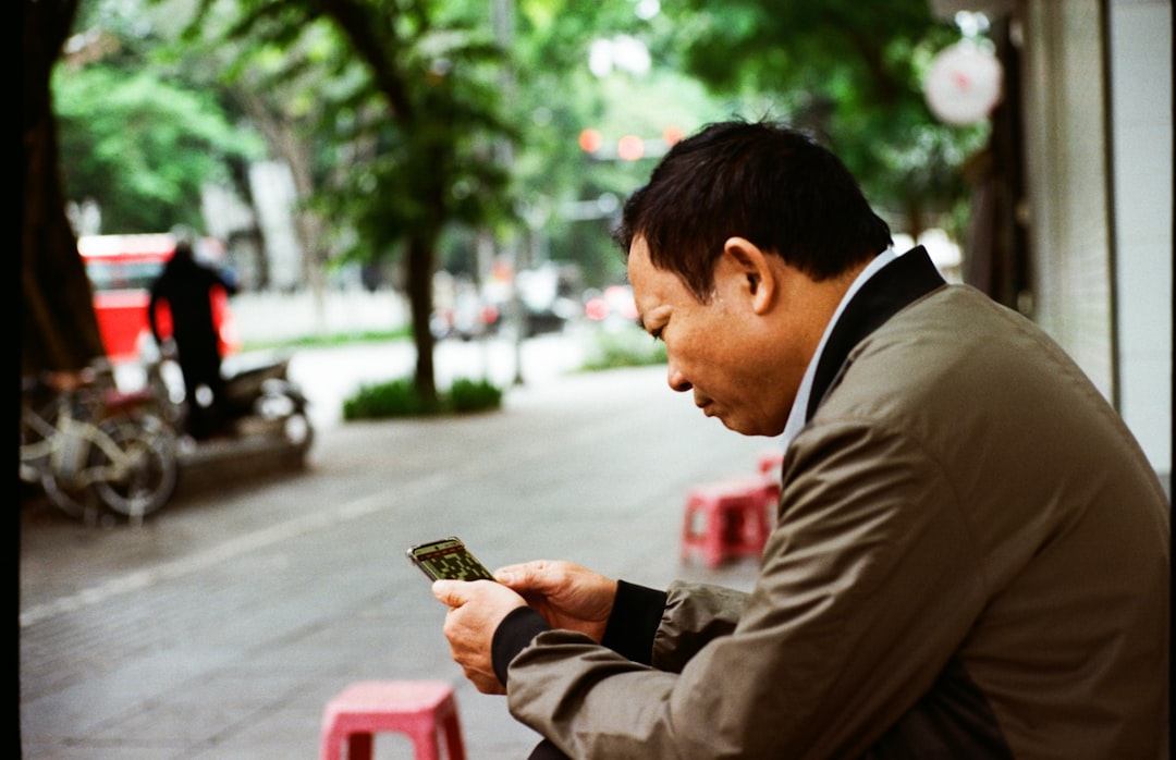 psychology of habit formation and streaks - Man looking at his phone on a street.