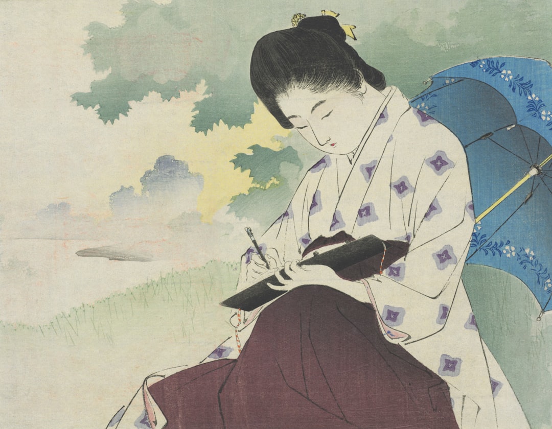 Woman in kimono writing under a blue umbrella