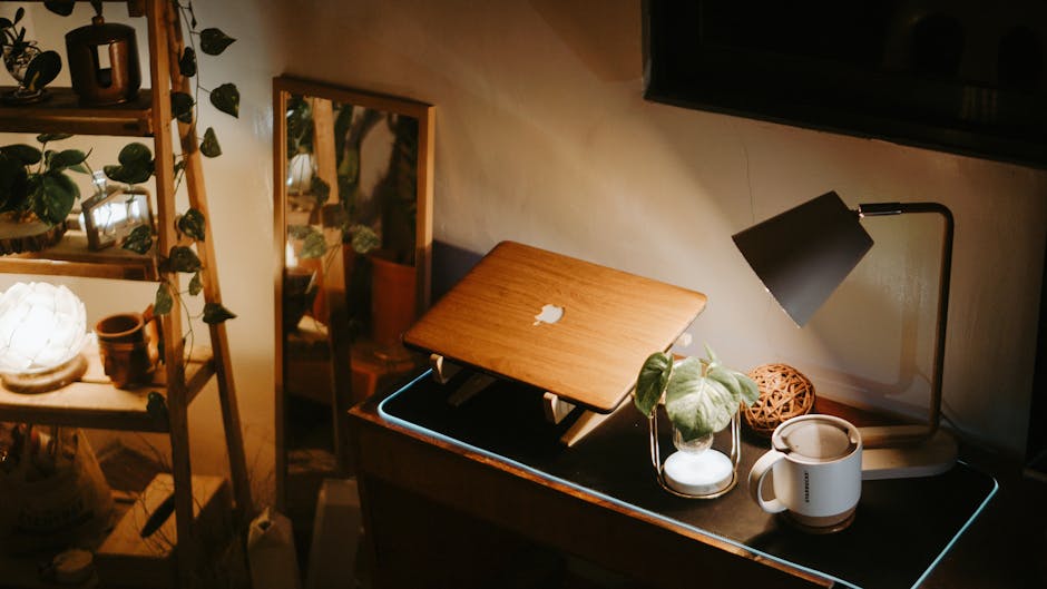 mindfulness news April 2026 - Warmly lit home workspace featuring a laptop, lamp, and green plants on a desk.