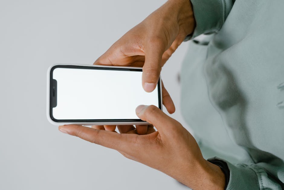 best meditation apps - Hands holding a smartphone with a blank screen, perfect for mockups or copy space.