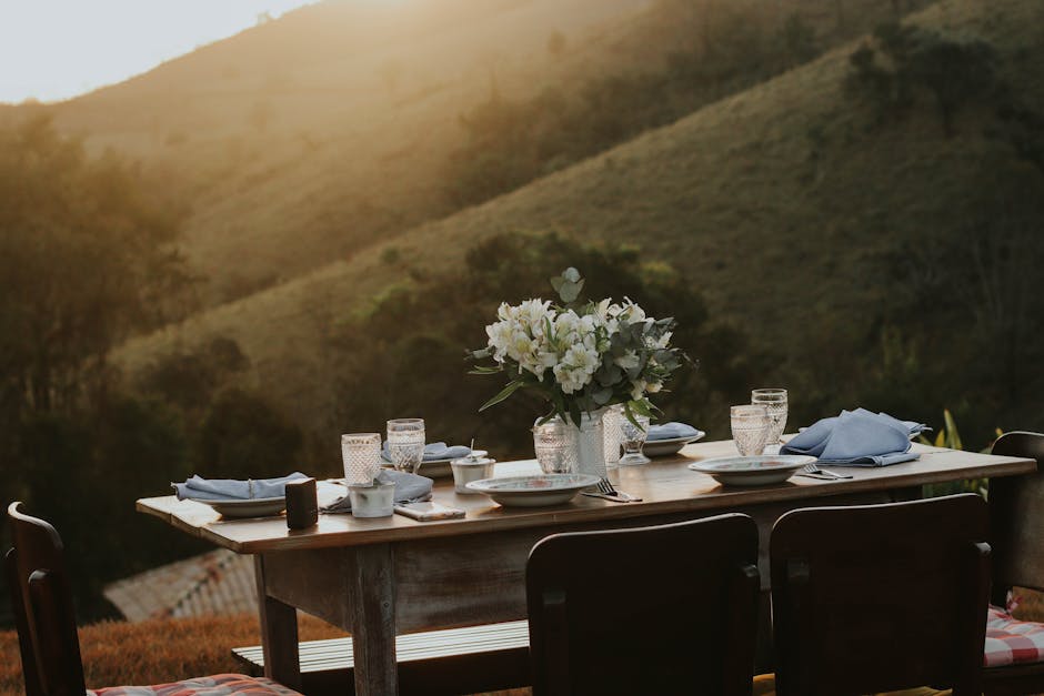 mindful eating - A beautifully arranged dining table outdoors with scenic hills at sunset, creating a serene atmosphere.