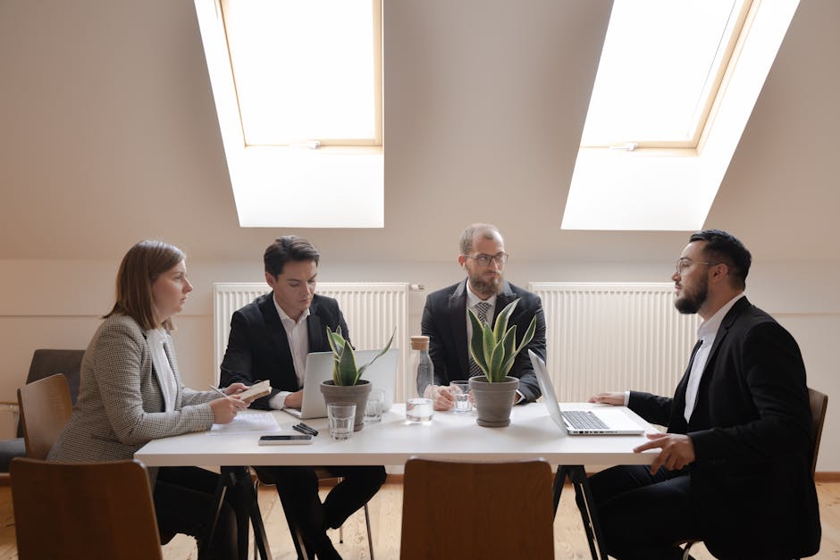 mindful leadership - Diverse group of professionals in formal meeting around a table.
