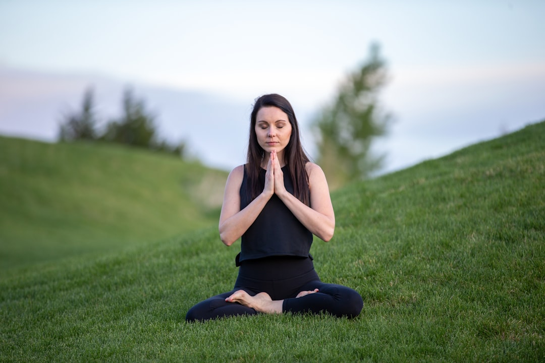 mindfulness news May 2026 - woman in black tank top and black pants sitting on green grass field during daytime
