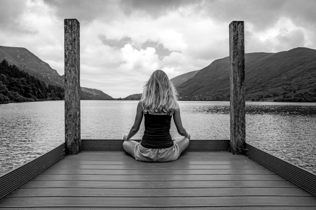 mindfulness news May 2026 - A woman sitting on a dock in front of a body of water