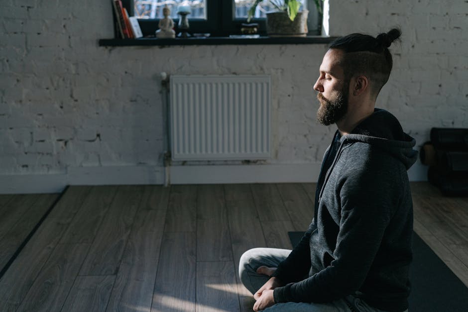 mindfulness news May 2026 - Side view of a man meditating indoors in a serene environment, promoting mental wellness and tranquility.