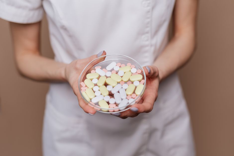 mindfulness and mental wellness - Close-up of a medical professional holding a petri dish filled with pills and tablets.