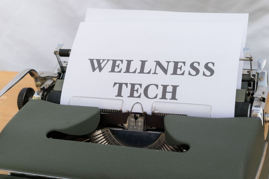 mental wellness - A close-up of a vintage typewriter featuring a paper with the words 'Wellness Tech.'