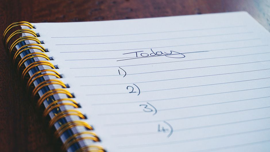 monotasking - A close-up view of a handwritten to-do list on a spiral notebook with numbers for tasks.
