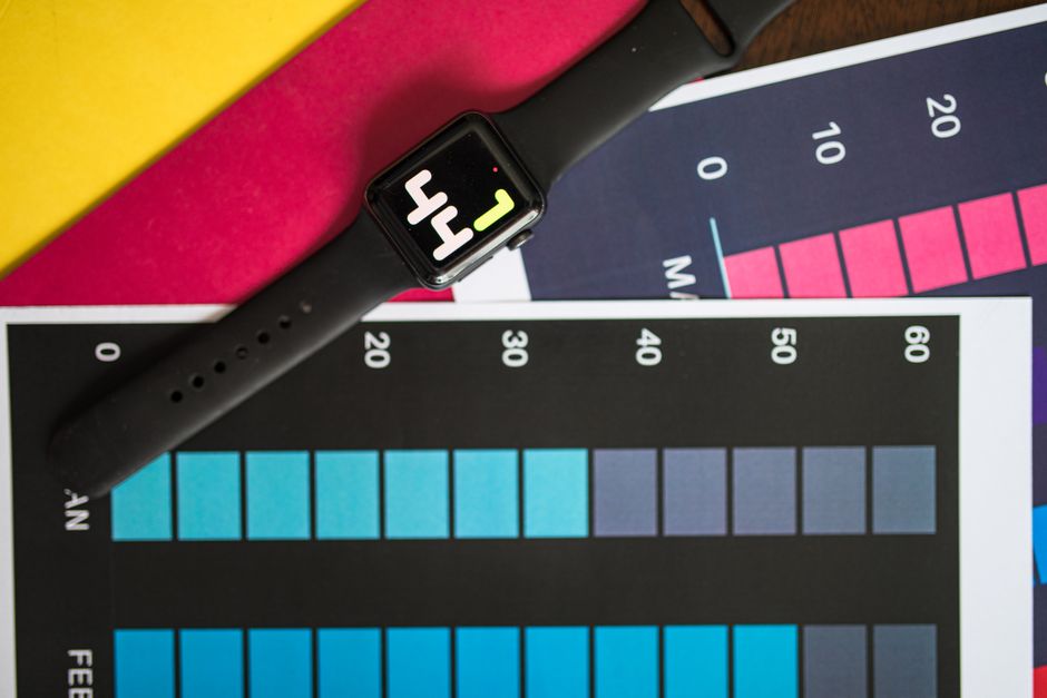 habit tracker for adhd - A smart watch resting on vibrant charts showing data visualization on a table.