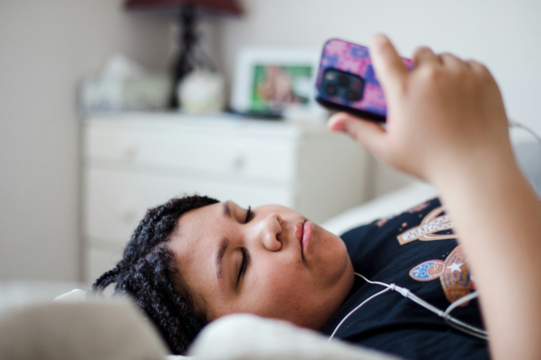 mental wellness news - a person laying in bed with a cell phone